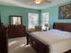 Spacious main bedroom with large bed, dresser, and seating area at 16052 Sw 15Th Ct, Ocala, FL 34473