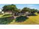 House surrounded by mature trees and a large grassy backyard at 17370 Se 76Th Flintlock Ter, The Villages, FL 32162