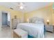 King-size bed, wicker furniture, and ensuite bathroom access at 17370 Se 76Th Flintlock Ter, The Villages, FL 32162