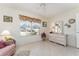 Bedroom with tiled floors, dresser, and window with garden view at 17370 Se 76Th Flintlock Ter, The Villages, FL 32162