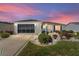 Single-story home with attached garage and landscaped yard at dusk at 17370 Se 76Th Flintlock Ter, The Villages, FL 32162