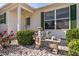 House entrance with stone bench, landscaping, and green shutters at 17370 Se 76Th Flintlock Ter, The Villages, FL 32162