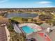 Community pool with lounge chairs, overlooking a golf course and lake at 17370 Se 76Th Flintlock Ter, The Villages, FL 32162