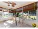 Sunroom with tiled floor, wicker chairs, and table at 17370 Se 76Th Flintlock Ter, The Villages, FL 32162