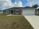 Newly constructed home with gray exterior, two car garage, and grassy lawn at 1776 Sw 161St Pl, Ocala, FL 34473