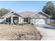 Single-story house with a two-car garage, screened porch, and partial fence at 201 Emerald Loop Pass, Ocala, FL 34472