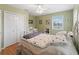 Serene bedroom with light green walls, hardwood floors, and a white metal bed frame at 20921 Sw 36Th St, Dunnellon, FL 34431