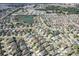 Aerial view of a large community with many houses and a pond at 2304 Grenadier Way, The Villages, FL 32162