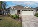 Single-story home with landscaped yard, attached garage, and paved driveway at 2304 Grenadier Way, The Villages, FL 32162