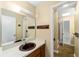 Bathroom with brown sink, mirror and adjacent hallway at 3827 Ne 17Th Street Cir, Ocala, FL 34470