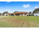 Tan house with brown roof, screened porch, and grassy yard at 4535 Nw 34Th Pl, Ocala, FL 34482