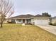 Single-story home with a two-car garage and well-maintained lawn at 4730 Se 31St St, Ocala, FL 34480