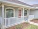 Front entrance with a covered porch and white railing at 4730 Se 31St St, Ocala, FL 34480