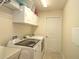 Laundry room with washer, dryer, and overhead cabinets at 4730 Se 31St St, Ocala, FL 34480