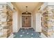 Covered entryway with stone columns and a wooden door at 4933 Sw 109Th Loop, Ocala, FL 34476