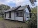 White cottage with metal roof and screened porch at 9100 Se 180Th Avenue Rd, Ocklawaha, FL 32179