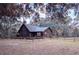 Rustic log cabin nestled in a wooded setting with a fenced yard at 9100 Se 180Th Avenue Rd, Ocklawaha, FL 32179