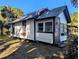 Quaint white cottage with a screened porch at 9100 Se 180Th Avenue Rd, Ocklawaha, FL 32179