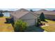 Rear exterior of home with a well-maintained roof, a two-car garage, and lush green landscaping at 9836 Sw 75Th Street Rd, Ocala, FL 34481