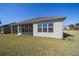 Backyard view featuring a screened-in lanai, and well-maintained landscaping at 9836 Sw 75Th Street Rd, Ocala, FL 34481