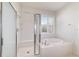 Bright bathroom featuring walk-in shower and soaking tub beneath a window with white shutters at 9836 Sw 75Th Street Rd, Ocala, FL 34481