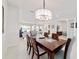 Elegant dining room featuring a modern chandelier, and a glimpse into the cozy living room at 9836 Sw 75Th Street Rd, Ocala, FL 34481