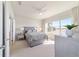 Well-lit bedroom with a ceiling fan, ensuite bath, neutral palette, and large window at 9836 Sw 75Th Street Rd, Ocala, FL 34481