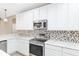 Kitchen with white cabinets, stainless steel appliances, and hexagon backsplash at 10384 Sw 41St Ave, Ocala, FL 34476