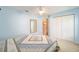 Bedroom with light blue walls, carpet, ceiling fan, and ample closet space at 11642 Sw 71St Cir, Ocala, FL 34476