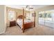 Main bedroom with a post bed, ceiling fan and access to a screened porch at 11642 Sw 71St Cir, Ocala, FL 34476