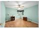 Bedroom with light teal walls, wood flooring, and a ceiling fan at 11642 Sw 71St Cir, Ocala, FL 34476