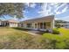 Rear view of house showcasing patio and well-maintained lawn at 11642 Sw 71St Cir, Ocala, FL 34476