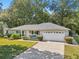 Single story home with a gray roof, white garage door, and manicured lawn at 14146 Sw 112Th Cir, Dunnellon, FL 34432