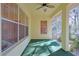 Cozy screened porch with ceiling fan and green flooring at 19247 Sw 98Th Loop, Dunnellon, FL 34432