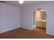 Bedroom with light-purple walls and an open doorway leading to the bathroom at 19950 Ibis Ct, Dunnellon, FL 34432