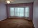 Spacious bedroom with bay windows and light-purple walls at 19950 Ibis Ct, Dunnellon, FL 34432