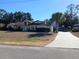 Single-story home with brown roof and attached garage.Landscaped yard at 19950 Ibis Ct, Dunnellon, FL 34432