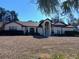 Tan one-story house with brown roof, manicured lawn, and palm tree at 19950 Ibis Ct, Dunnellon, FL 34432