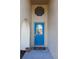 Charming entryway with a blue front door, transom window, and stucco walls at 19950 Ibis Ct, Dunnellon, FL 34432