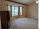 Cozy living room featuring a bay window, neutral carpet, and decorative wallpaper border at 19950 Ibis Ct, Dunnellon, FL 34432