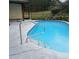 Screened pool has a handrail and a landscaped retaining wall for privacy at 19950 Ibis Ct, Dunnellon, FL 34432