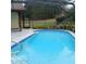 The pool has a screened enclosure and landscaped retaining wall for privacy at 19950 Ibis Ct, Dunnellon, FL 34432