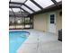 The screened in pool and deck area are next to the house, with an exterior door at 19950 Ibis Ct, Dunnellon, FL 34432