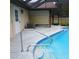 Pool with blue tile trim, handrail, and a covered patio with a roll down shade at 19950 Ibis Ct, Dunnellon, FL 34432