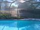 Inviting pool with a waterfall and a screened enclosure at 19950 Ibis Ct, Dunnellon, FL 34432