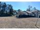 Rear view of home with partial fence visible plus view of adjacent property and yard at 19950 Ibis Ct, Dunnellon, FL 34432