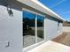 View of back patio with sliding glass doors and gray exterior at 201 Locust Rd, Ocala, FL 34472