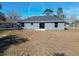 Large backyard with a home featuring a gray exterior and a grassy area at 201 Locust Rd, Ocala, FL 34472