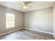 Neutral bedroom featuring vinyl floors, ceiling fan, and bright window with natural light at 201 Locust Rd, Ocala, FL 34472