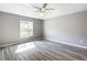 Bedroom with vinyl floors, ceiling fan, and bright window looking out onto the yard at 201 Locust Rd, Ocala, FL 34472